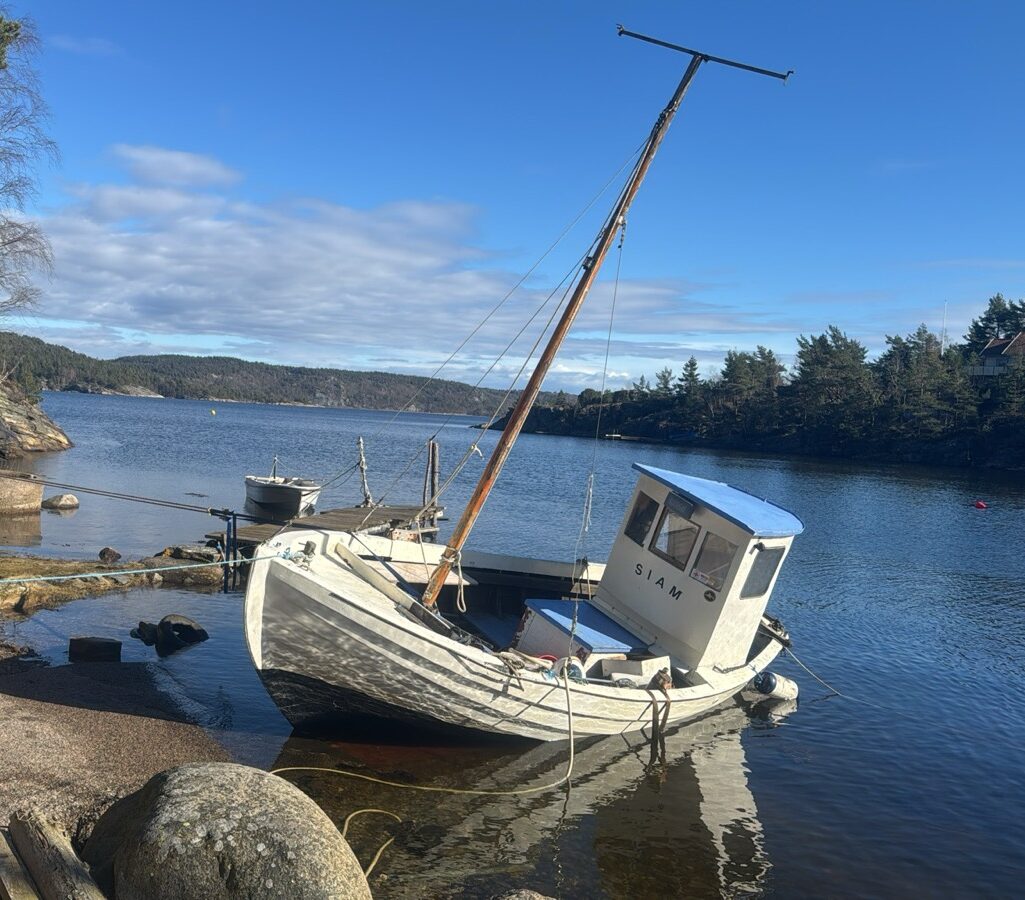 Siam boat taking in water in the sunny harbour